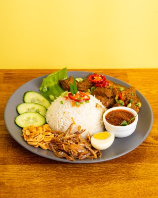 Nasi lemak with ayam goreng berempah - Rice cooked in coconut milk and lemongrass, served with peanut, anchovies, sambal with fried chicken marinated in Malaysian Spices